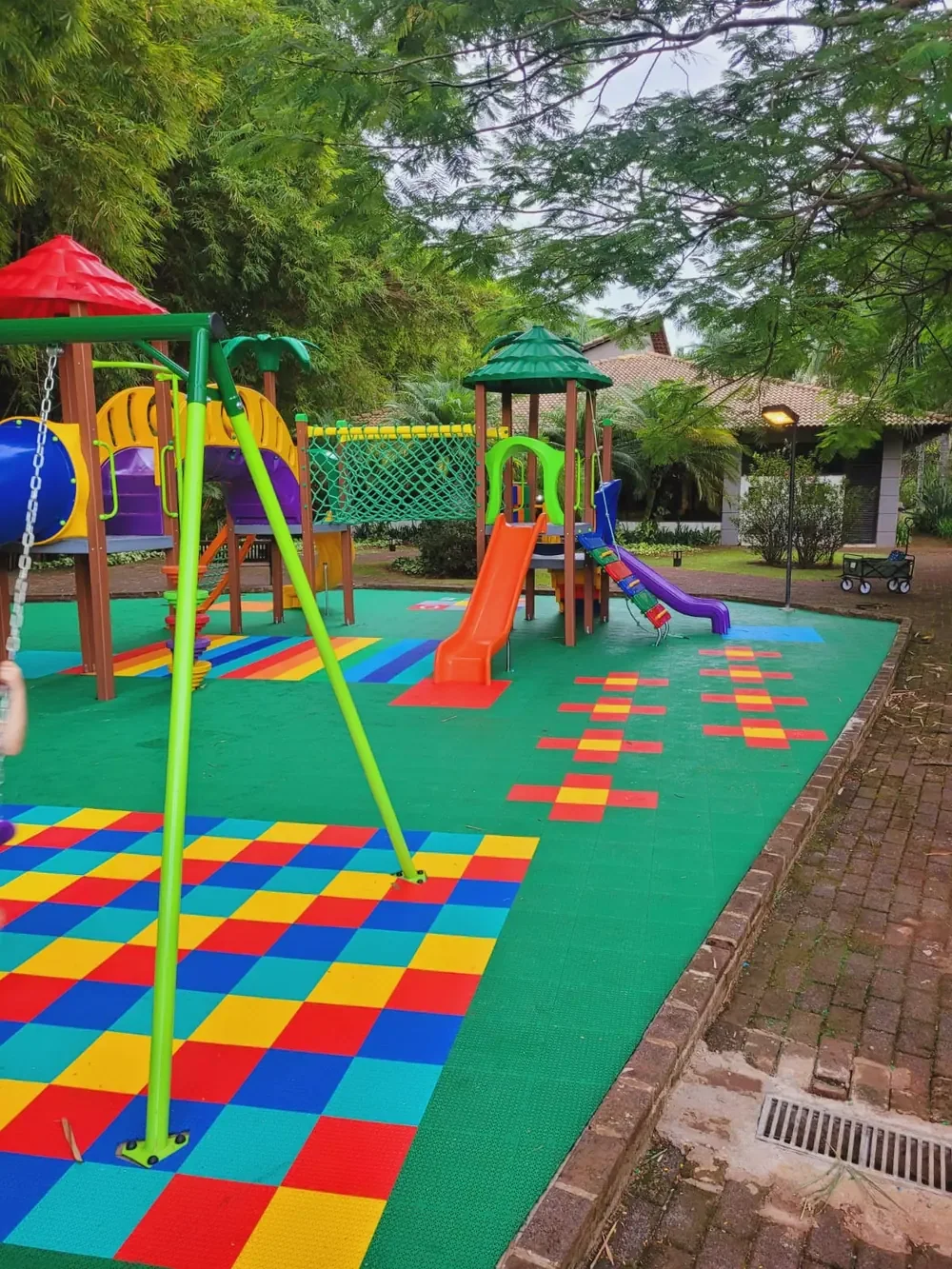 Playground com piso verde e composição quadriculada colorida